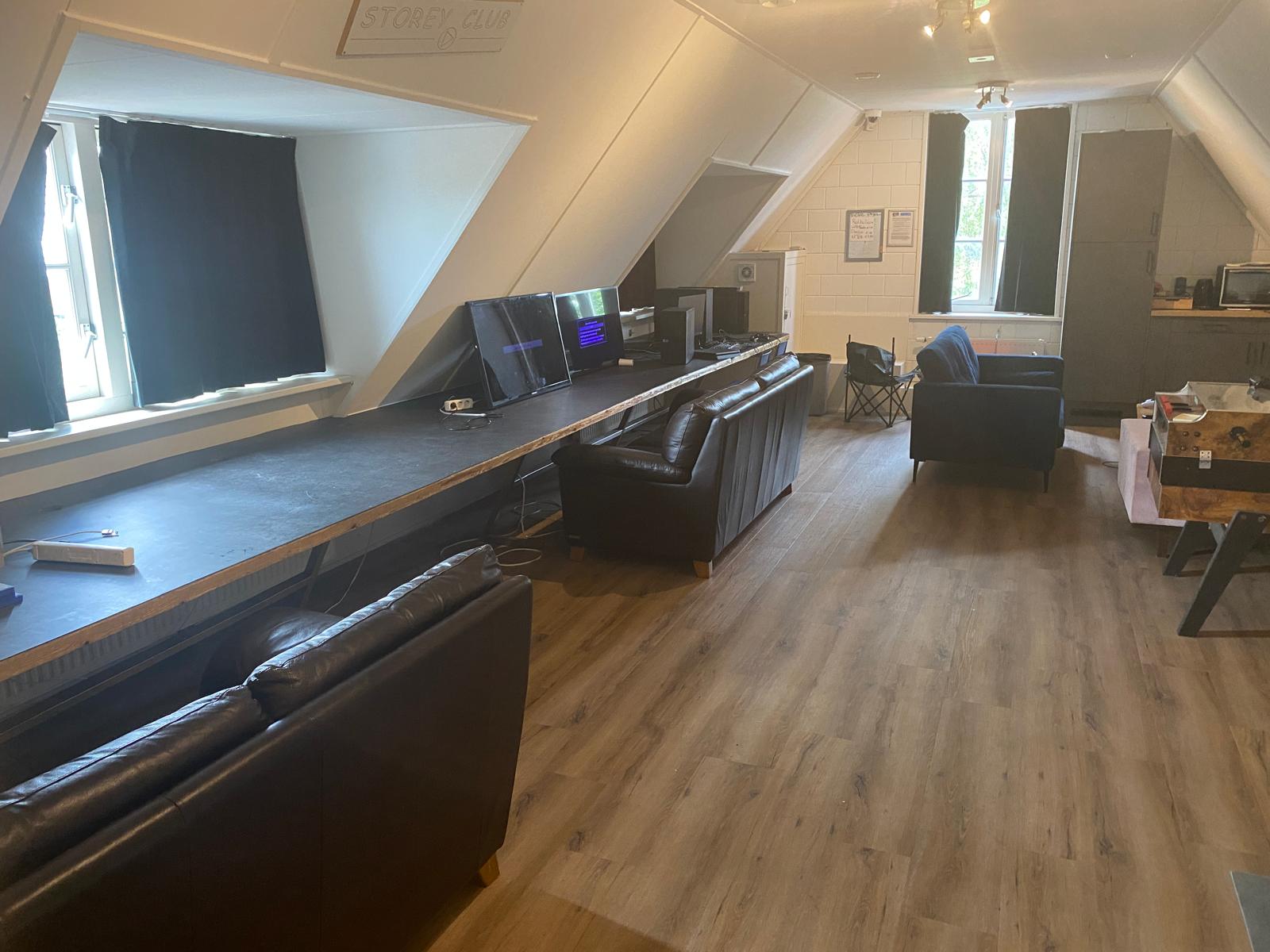 Het internetcafé van The Storey Club, met een lange werkbank met schermen, banken en een tafelvoetbal