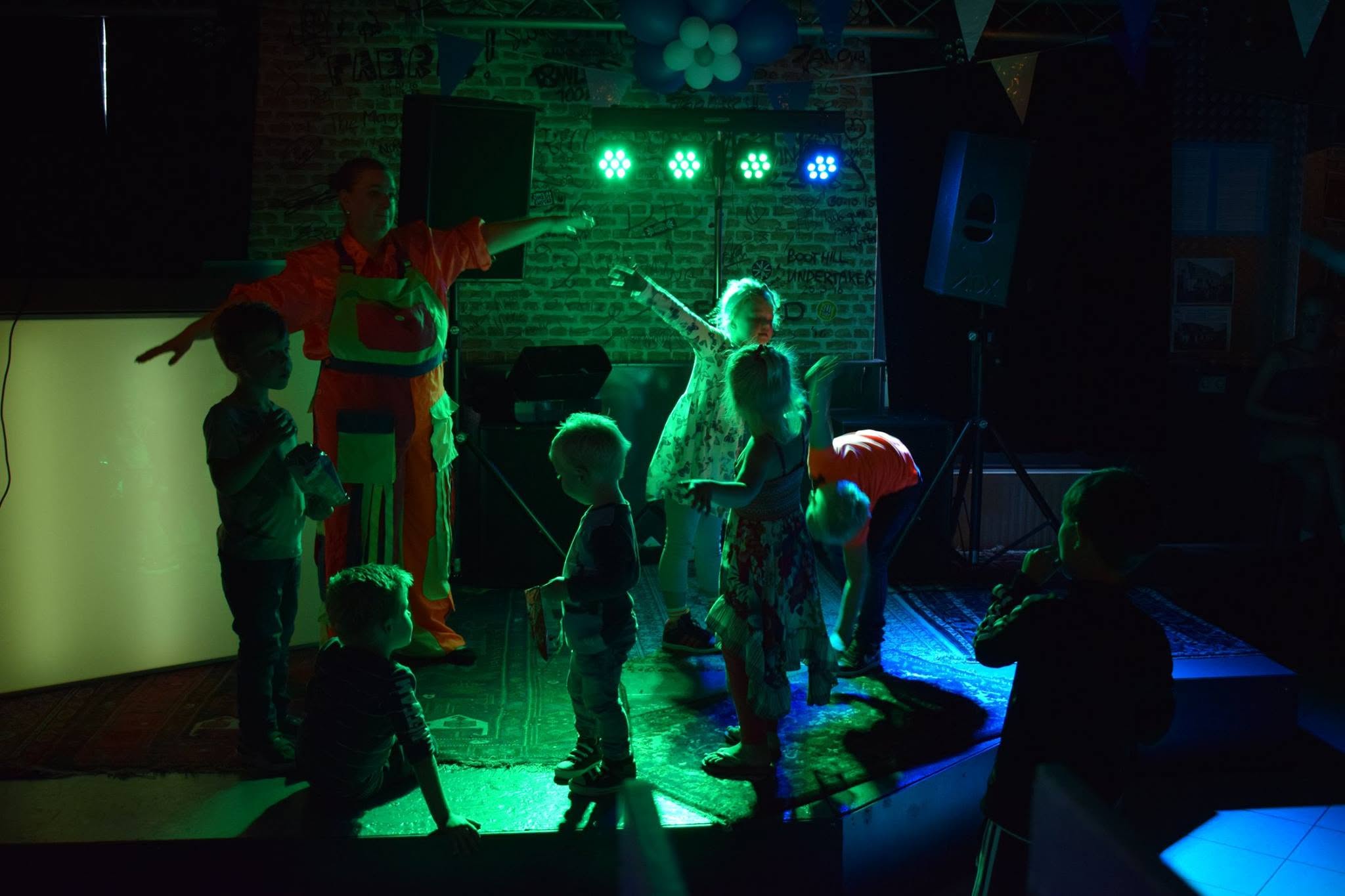 Kinderen dansen op het podium onder gekleurd licht